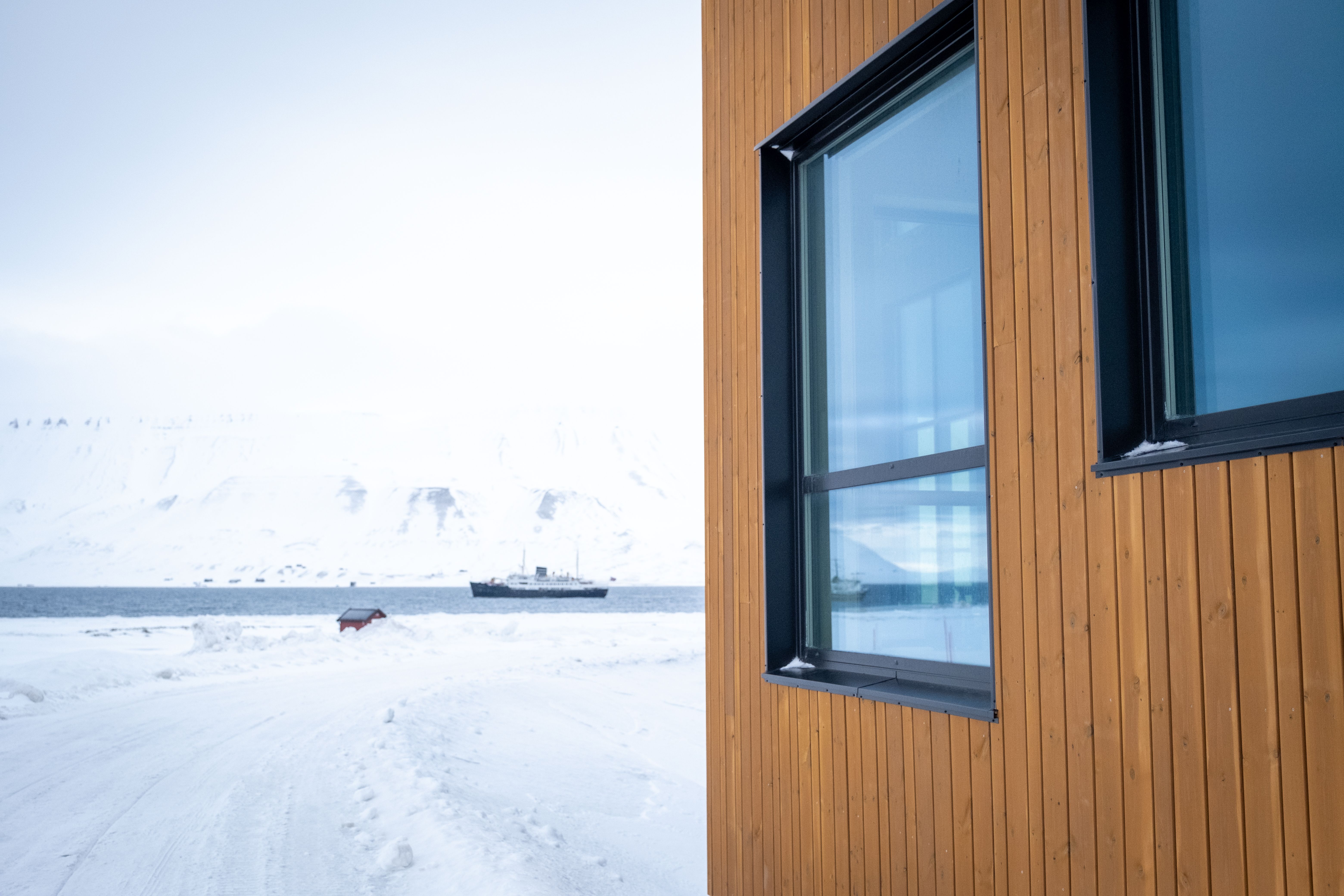 Svalbard folkehøgskole med båt i bakgrunnen. 