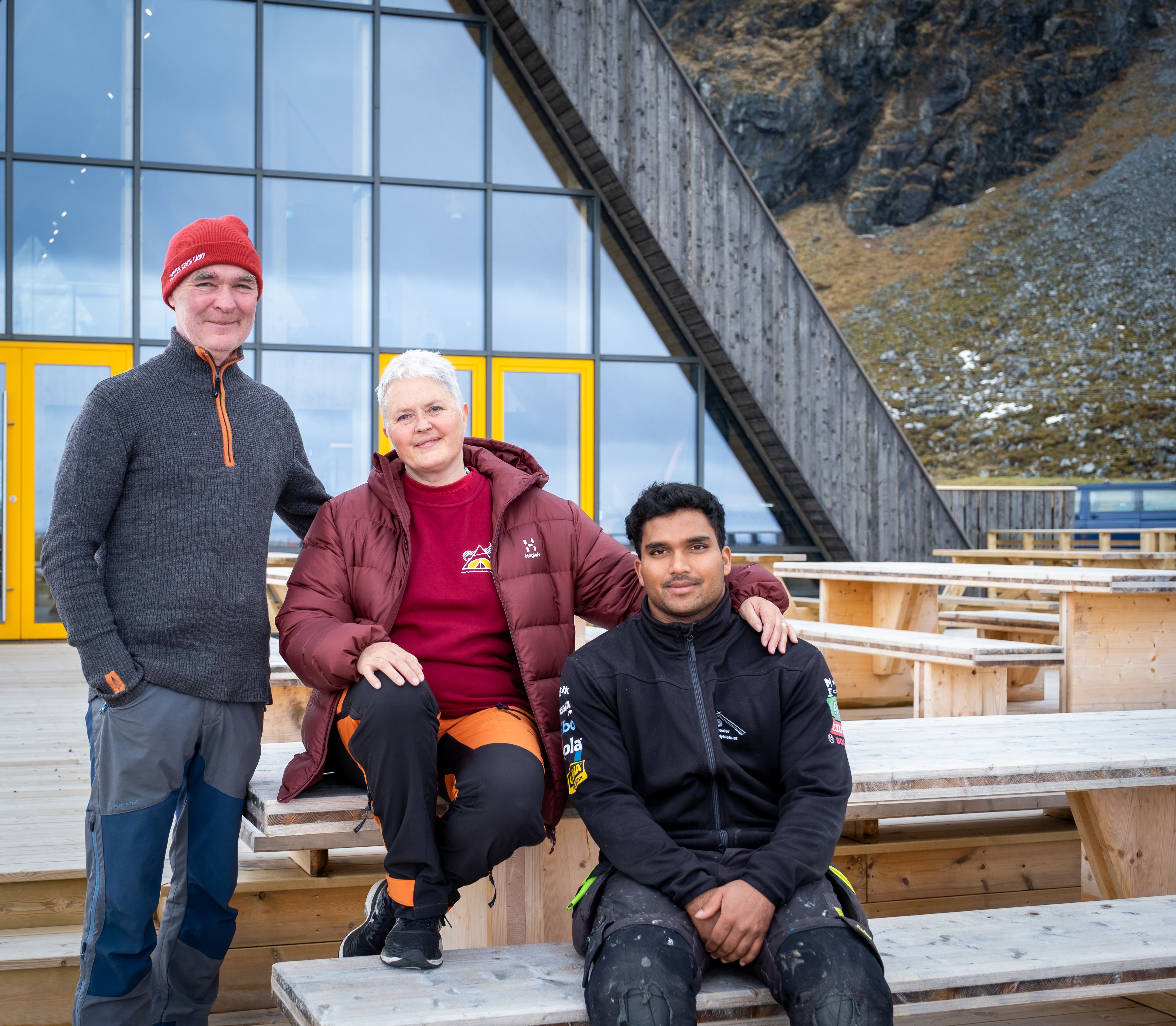 Per, Ellen og Lars sitter ute foran det flotte bygget sitt. 