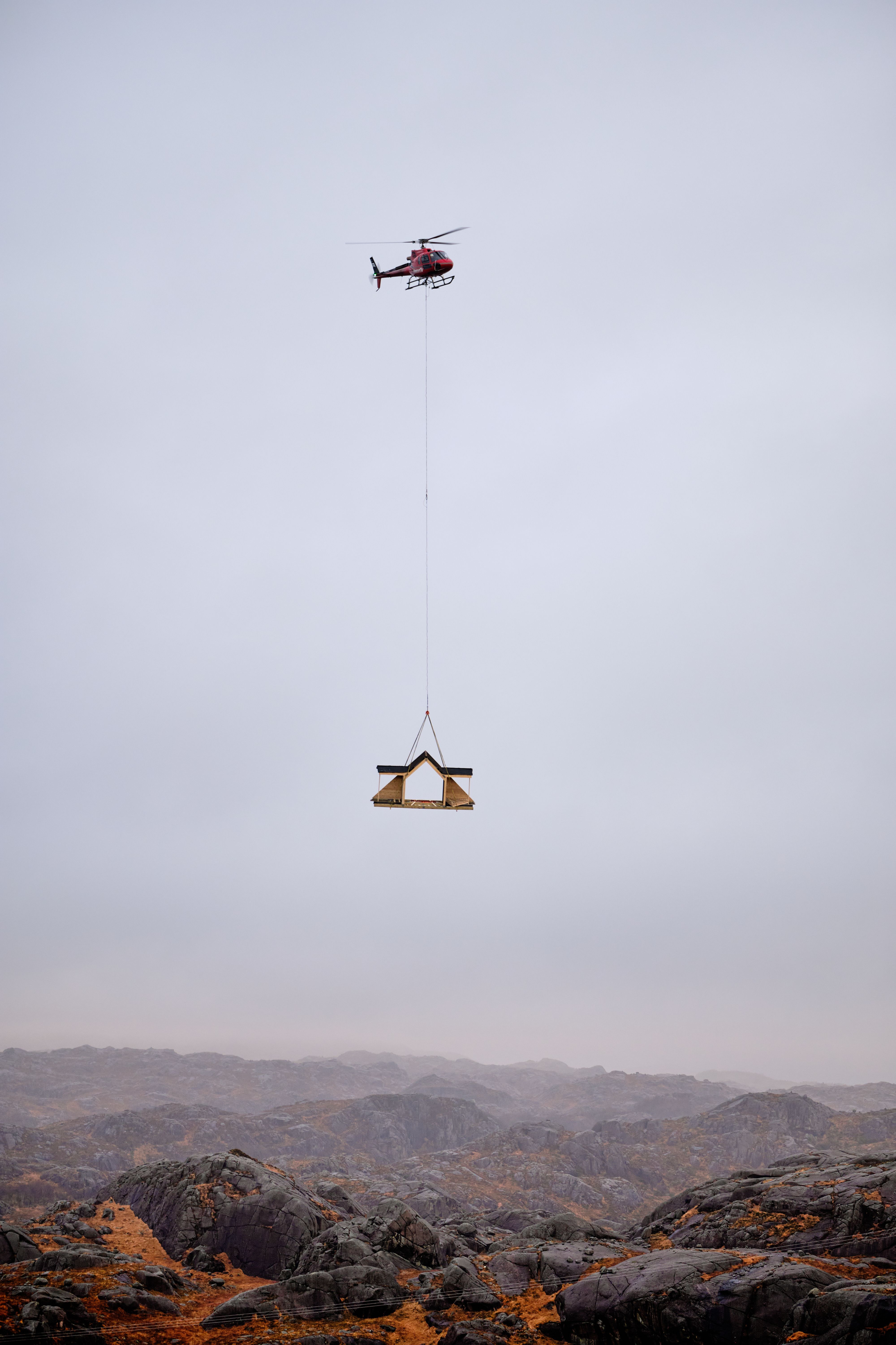 Hyttene flys på plass med helikopter. 