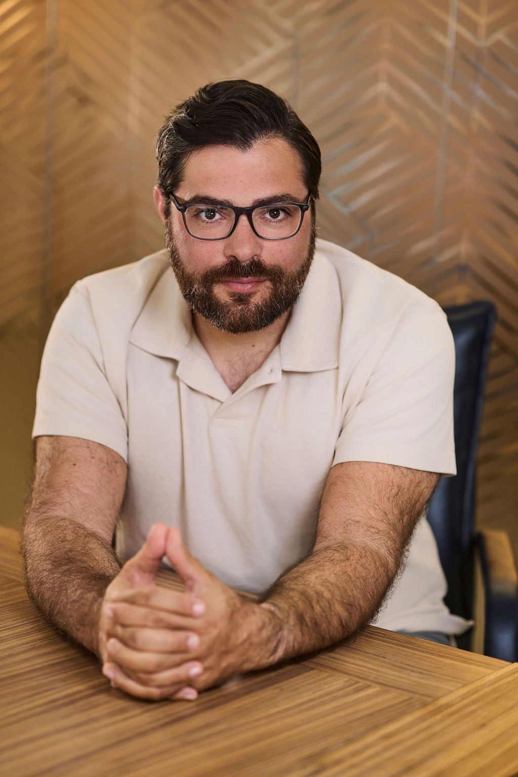 Jake sitting on a chair in a bright office space