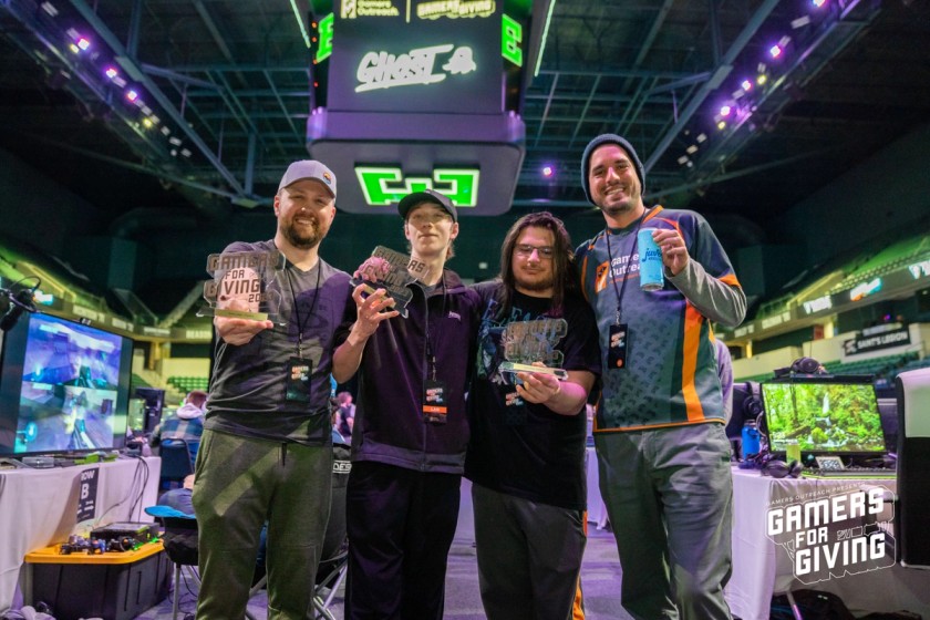 Tournament winners holding Gamers for Giving 2023 trophies.