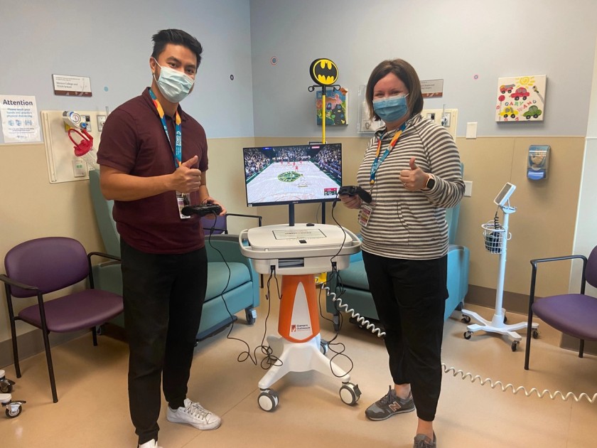 Healthcare staff with a Gamers Outreach GO Kart, video games for kids in hospitals