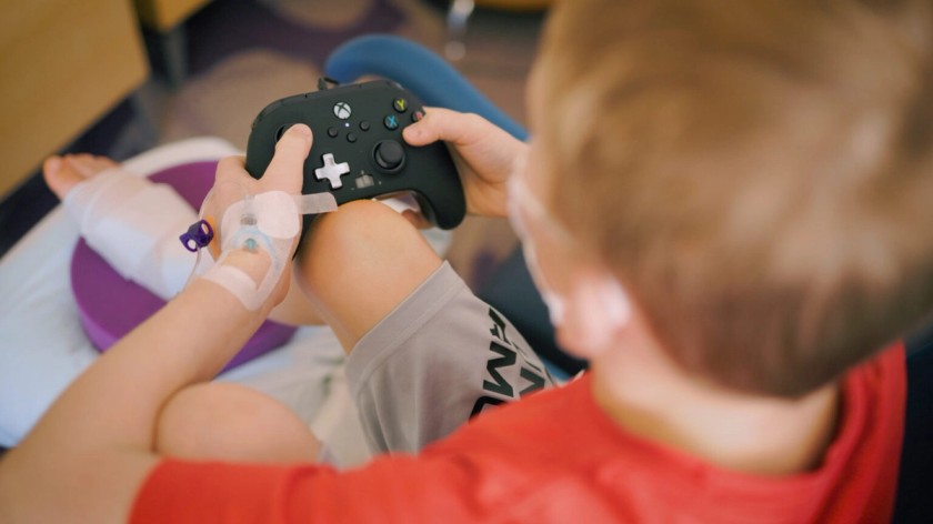 A child playing video games in a hospital thanks to a Gamers Outreach donation.