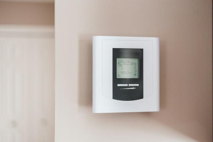 A digital room thermostat on a wall showing 22.5 degrees.