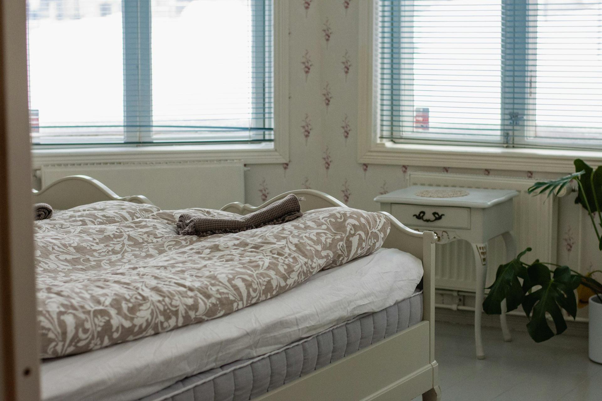 A bright bedroom with white radiators beneath the windows.