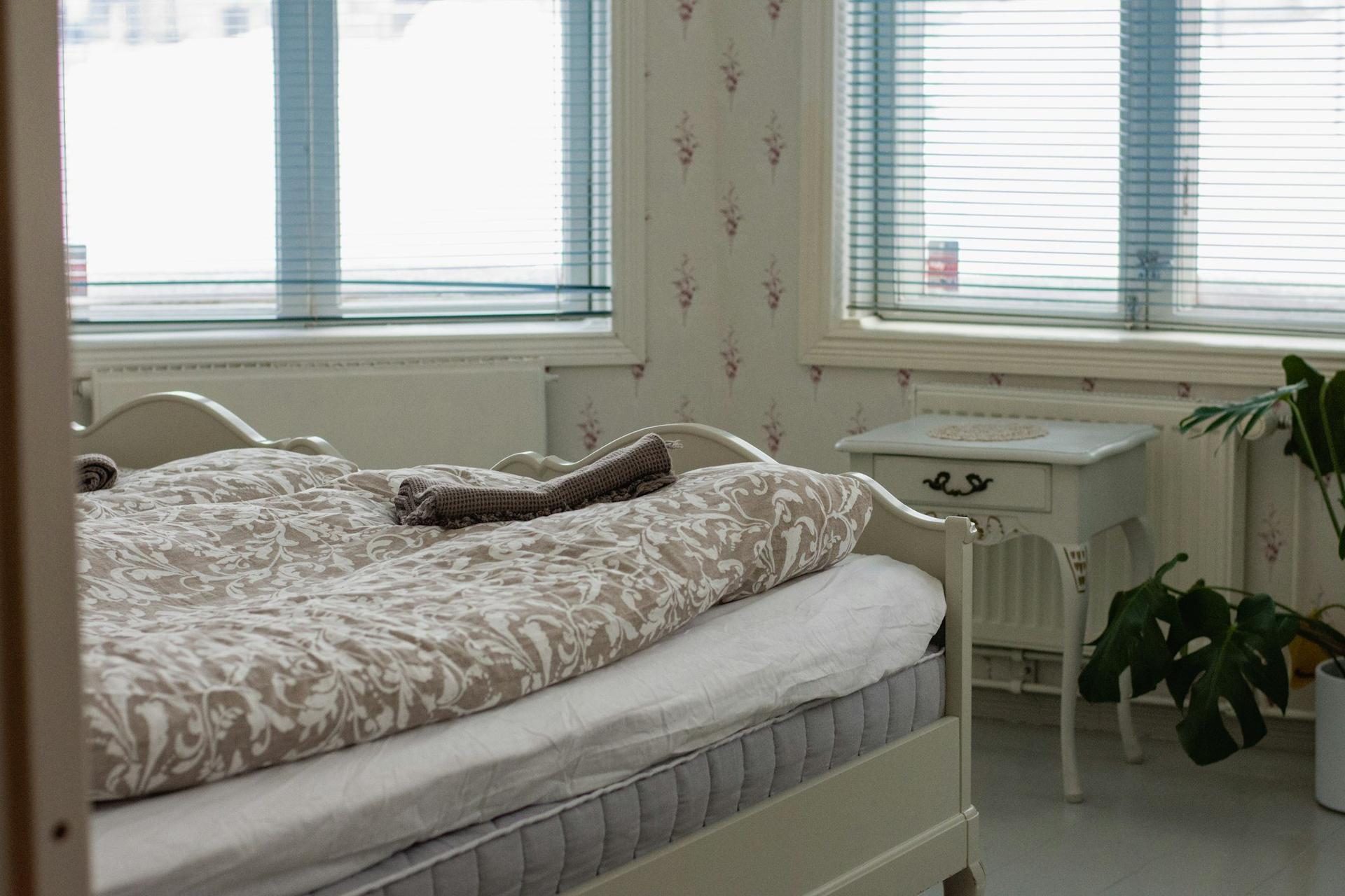 A bright bedroom with white radiators beneath the windows.