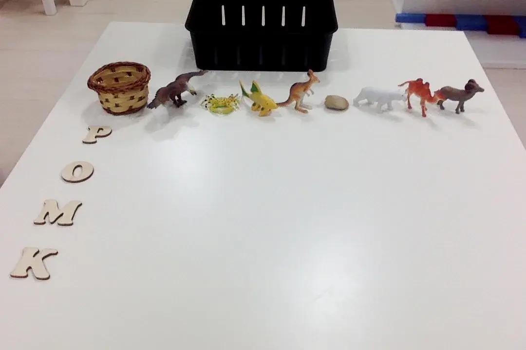подредени играчки-животни и дървени букви