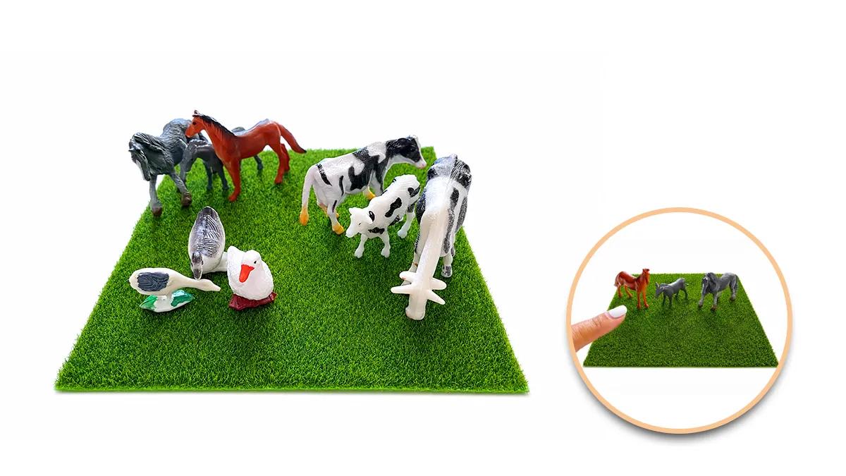 Миниатюрни играчки на животни върху зелена изкуствена трева