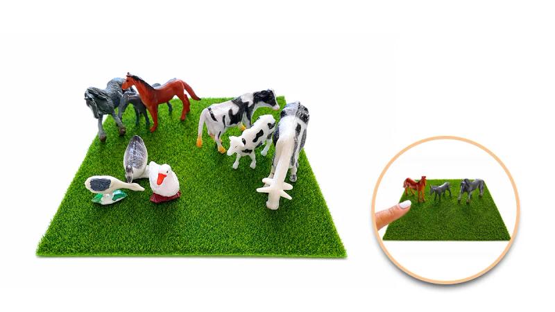Миниатюрни играчки на животни върху зелена изкуствена трева
