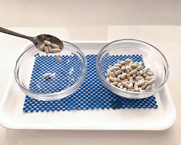 пресипване на бобени зърна с лъжица от една купа в други