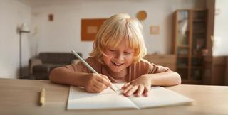 дете пише с молив на тетрадка