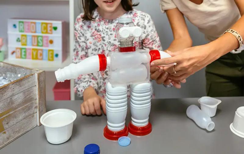 жена държи играчка направена от пластмаса