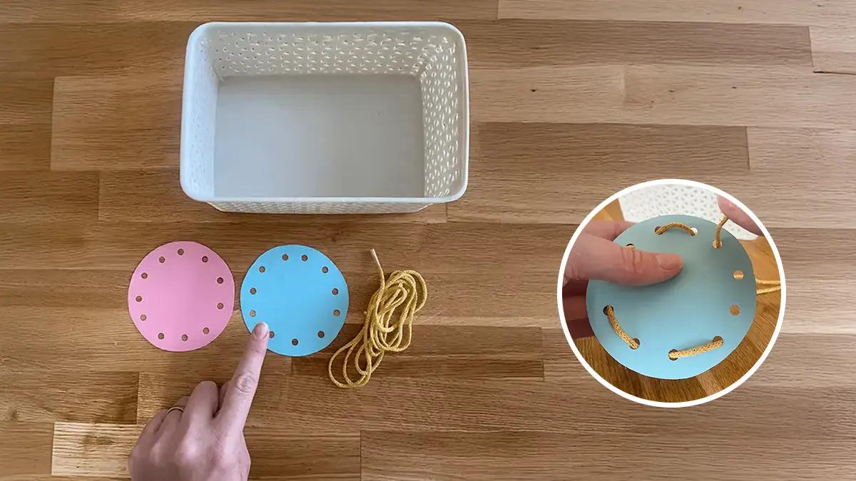 бял панер поставен до розов и син кръг с дупки и връвчица