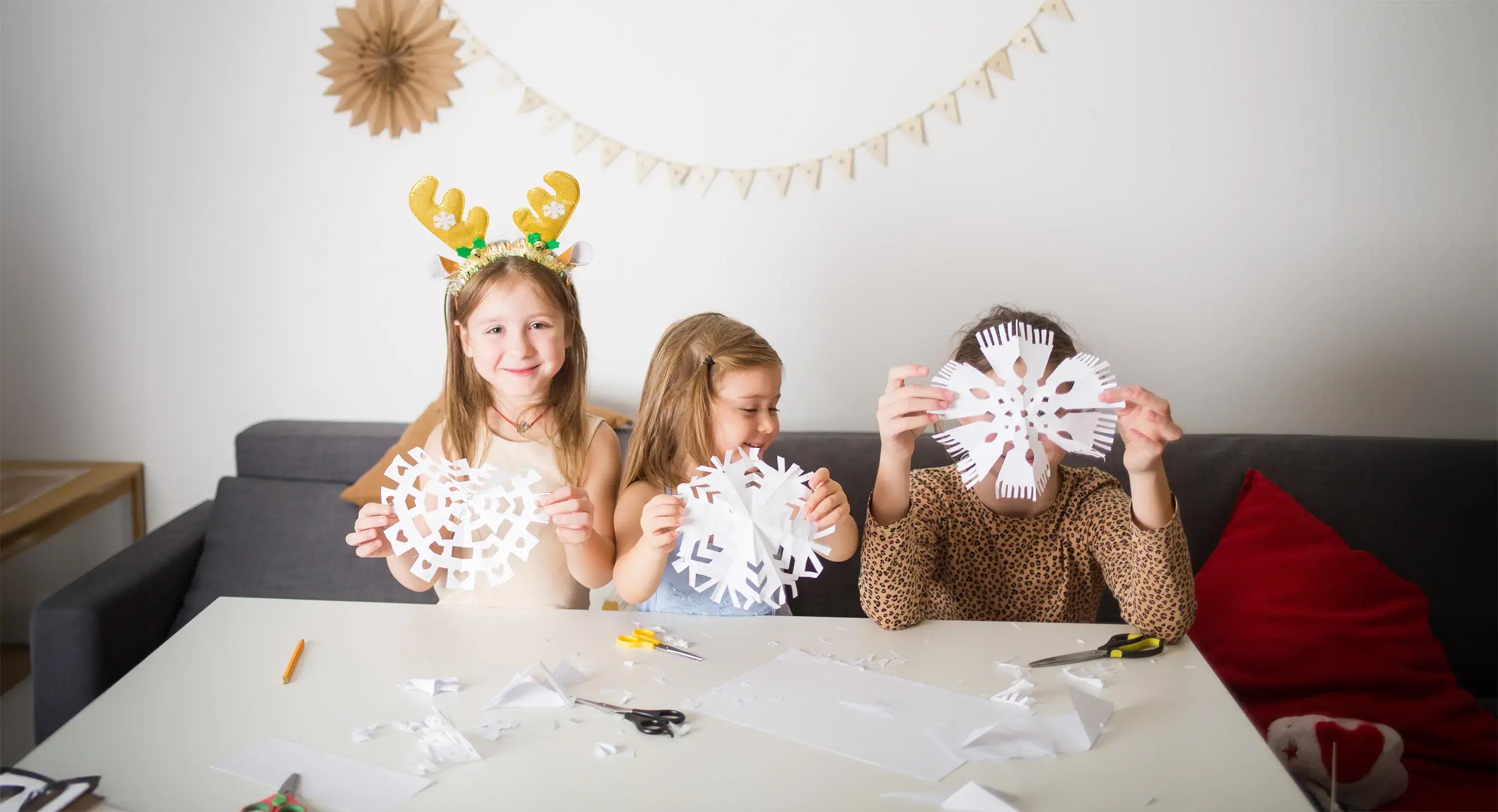 три деца изработват украса от хартия