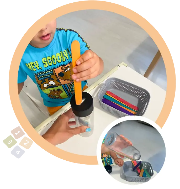 дете подпъхва плоска пръчица в кутия с процеп тип касичка