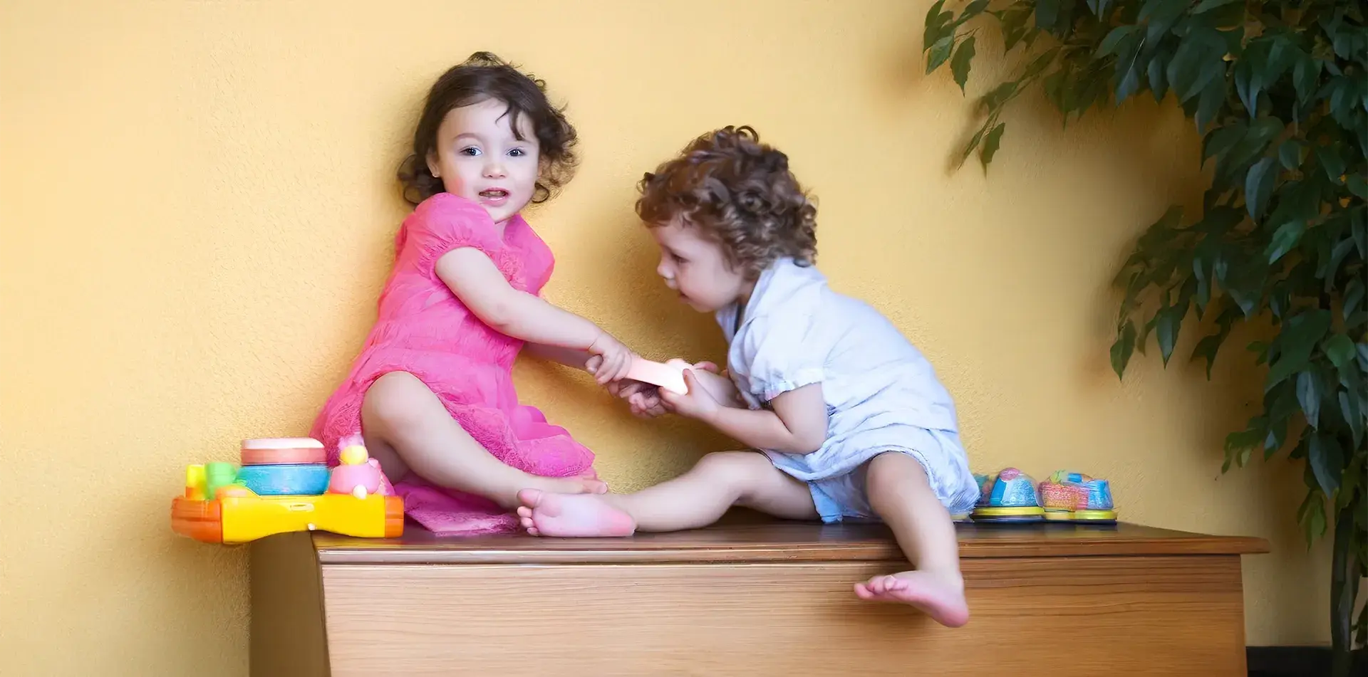 дете дърпа играчка от друго дете