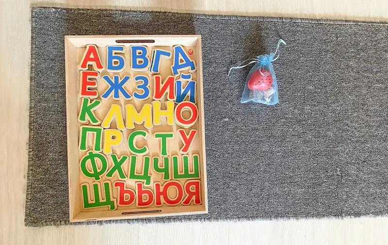 дървена кутия с букви и торбичка с ягодка