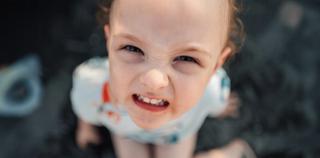 Малко дете с намръщено лице, гледащо нагоре.