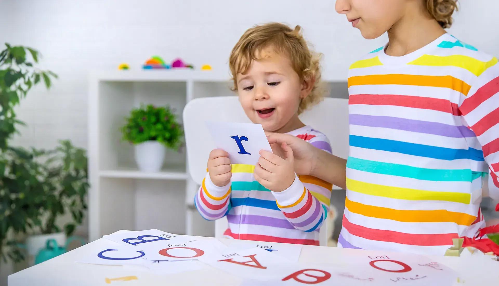 дете разлежда карти с английски букви