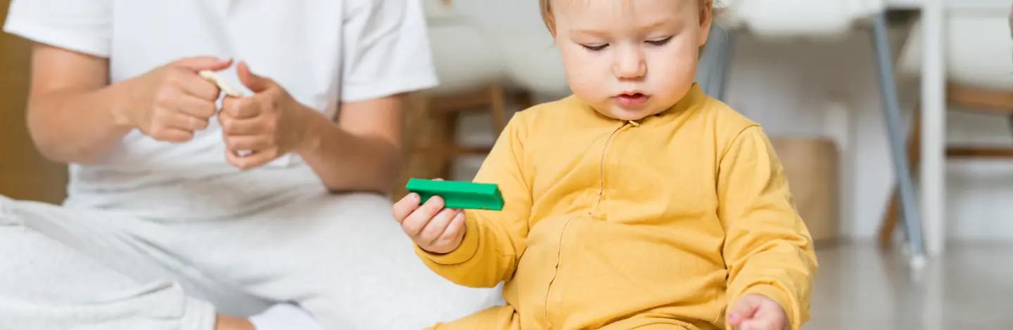 Дете с дървена монтесори играчка в ръка