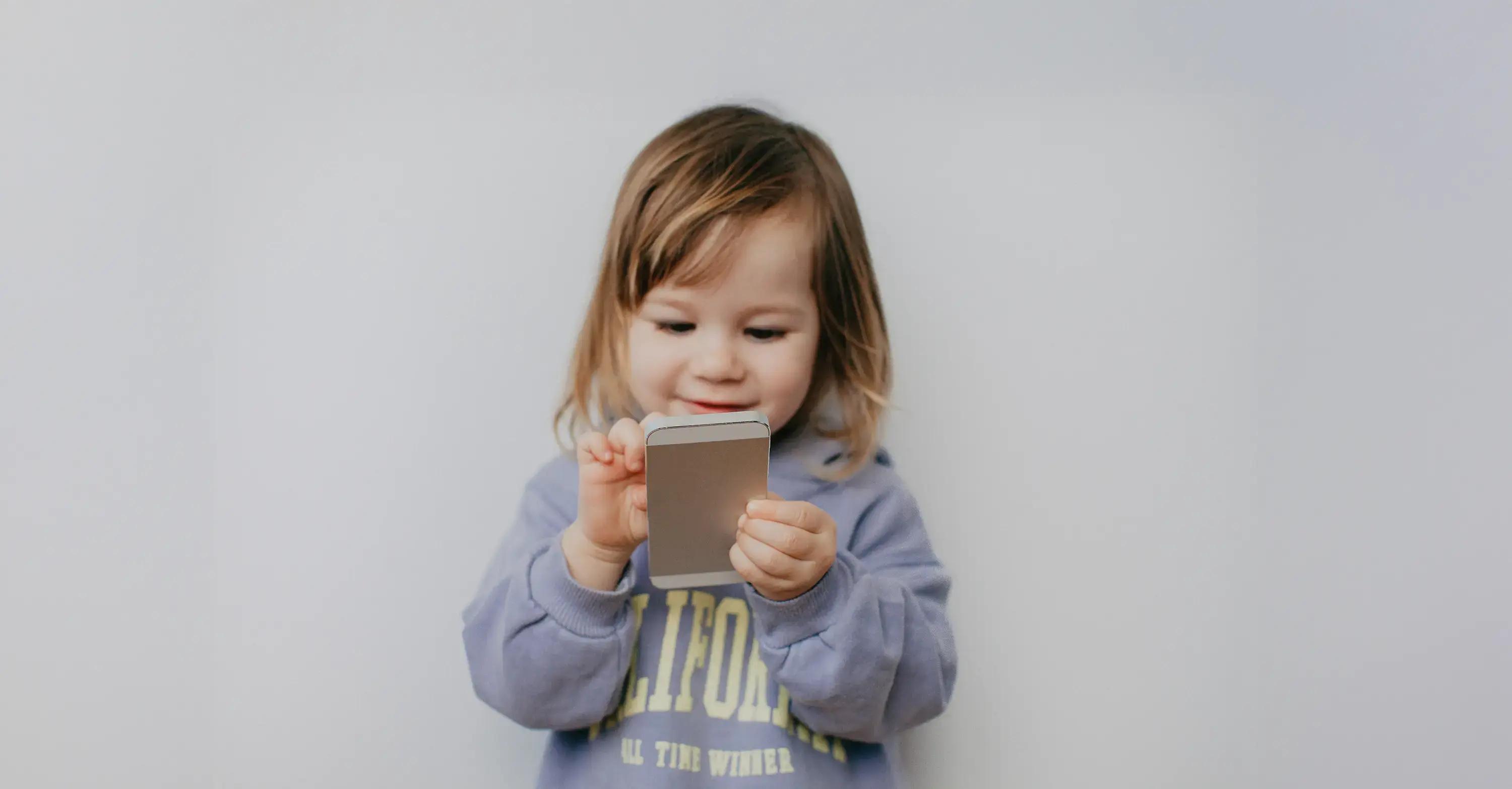 дете гледа телефон радостно