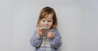 дете гледа телефон радостно