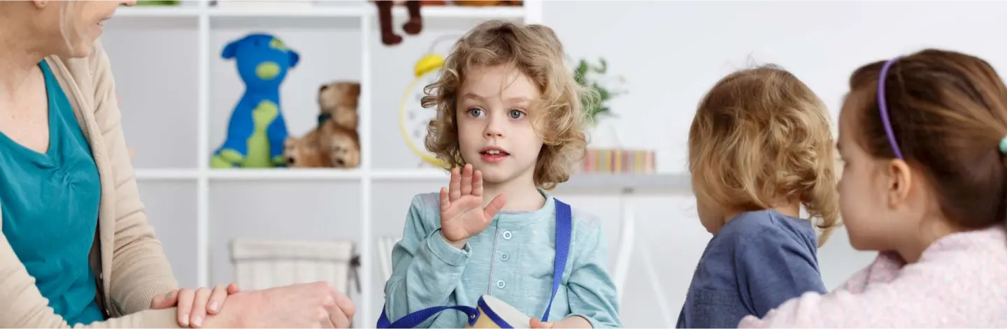 Дете с вдигната рака в монтесори класна стая