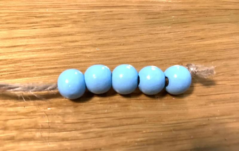 5 мъниста нанизани на връв с възел