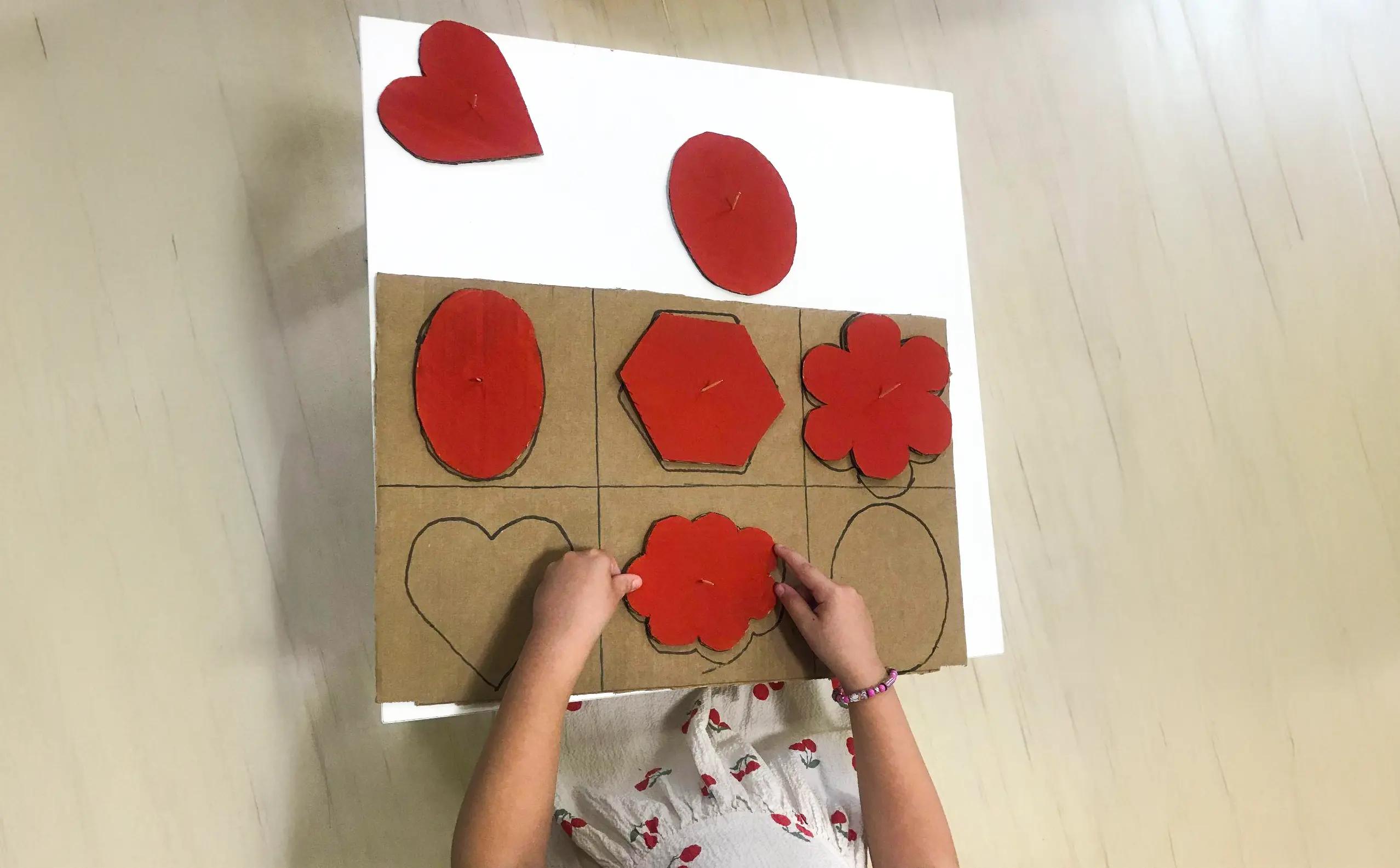 дете поставя картонена форма на мястото и в таблото