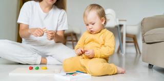 Дете с дървена монтесори играчка в ръка