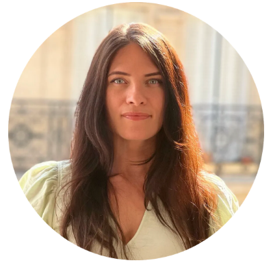 Headshot of a woman with long dark hair and light eyes, wearing a light green top.
