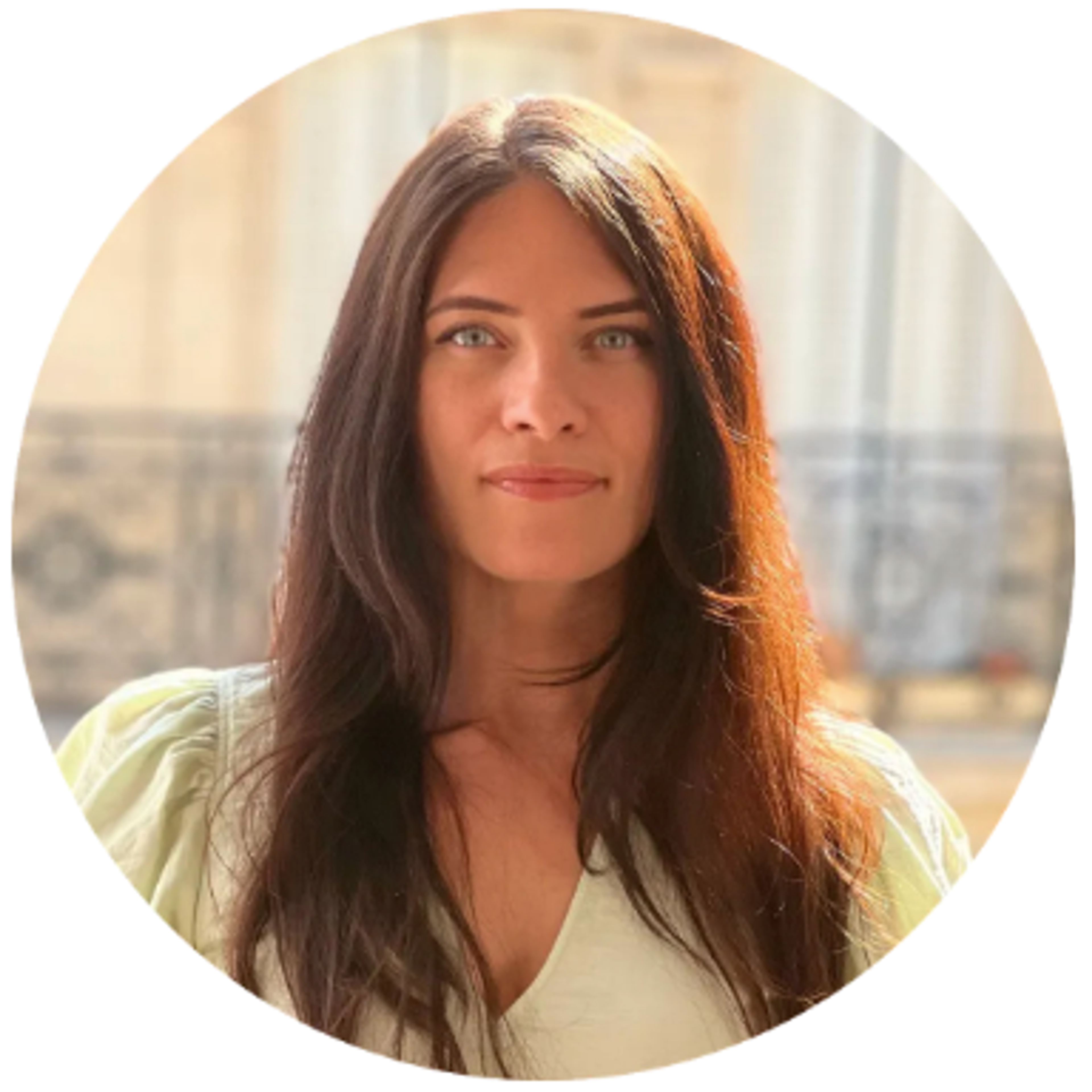Headshot of a woman with long dark hair and light eyes, wearing a light green top.