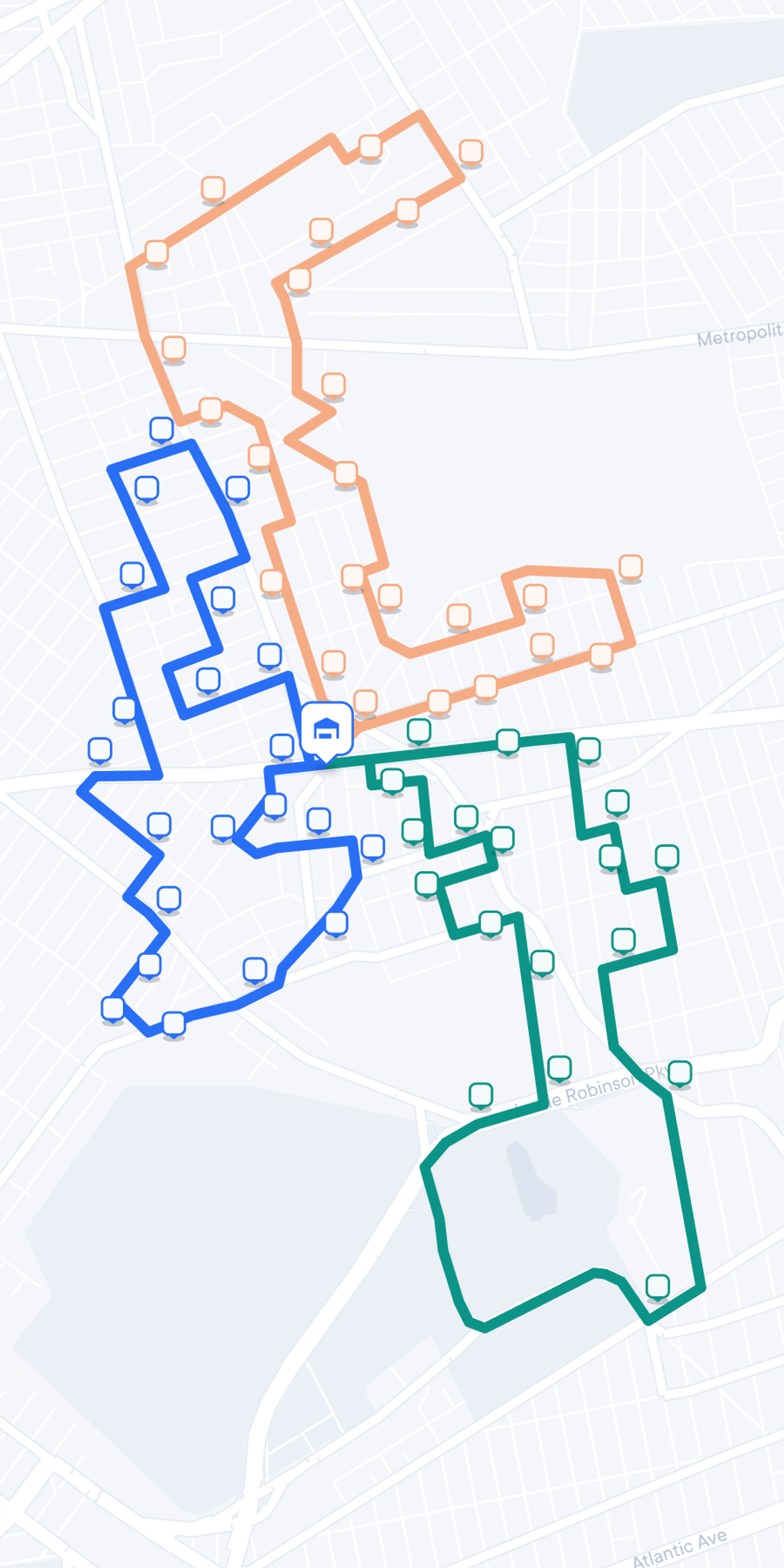 A city map similar to the first image, now displaying three distinct delivery routes in different colors: blue, orange, and green. Each colored line connects a series of square icons representing stops along the route, all originating from the central depot icon. The map visualizes optimized routing paths for deliveries.