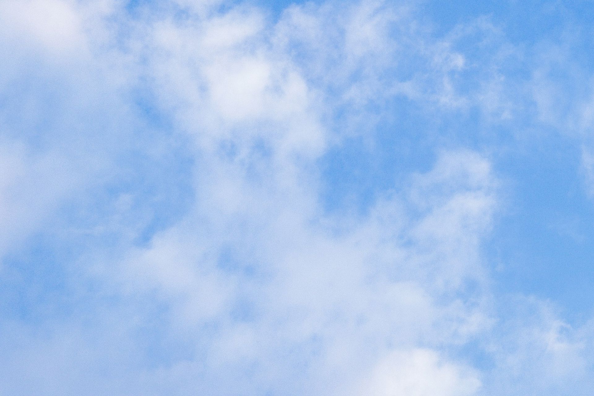 Blue sky with scattered white clouds.