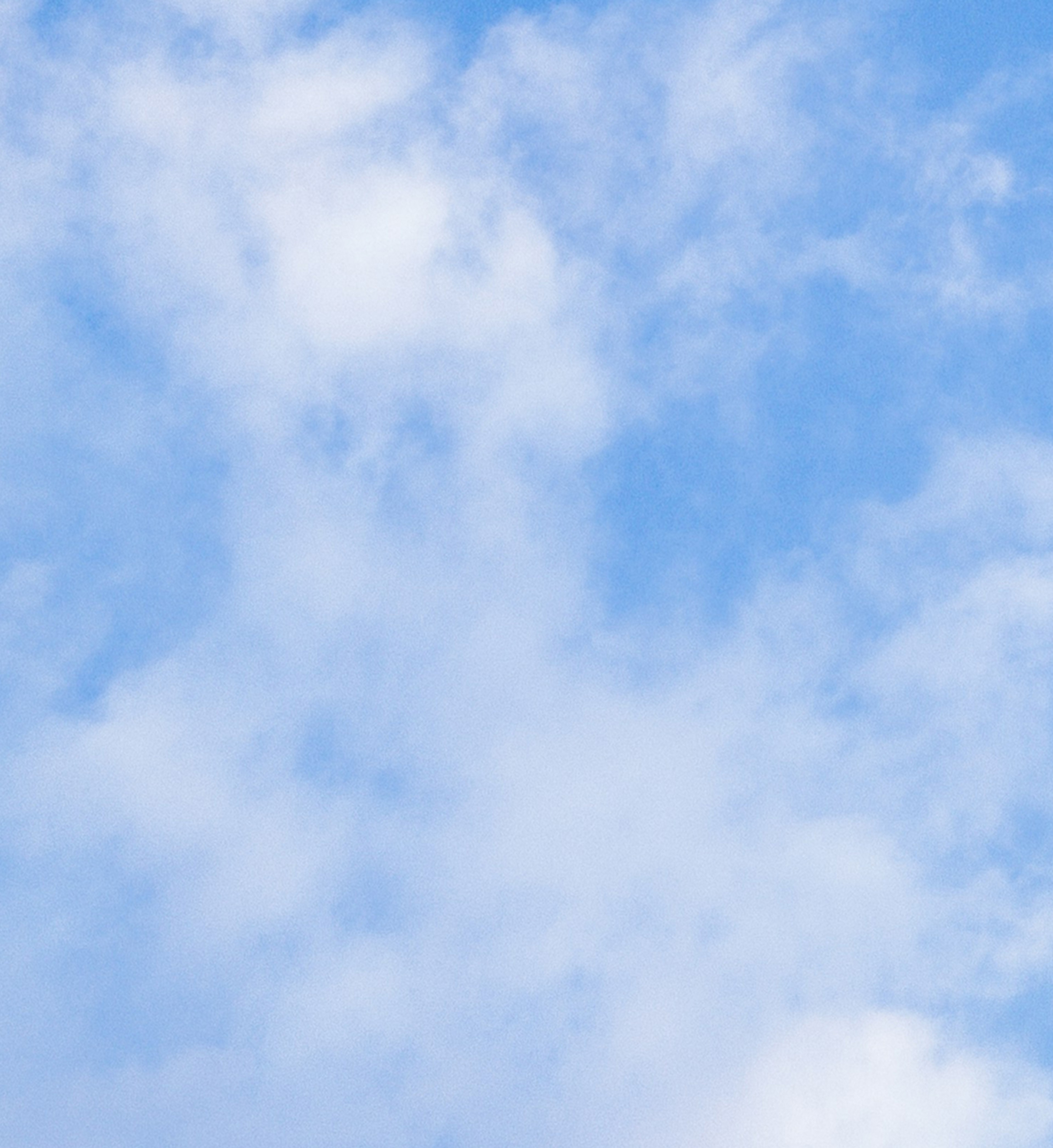 Blue sky with scattered white clouds.