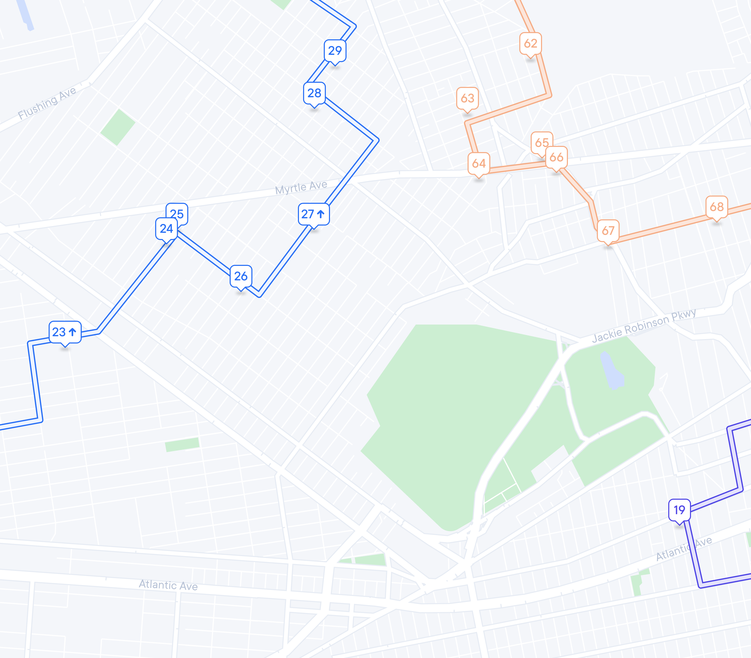 A map showing three numbered routes in blue, orange, and purple, with street names and parks.