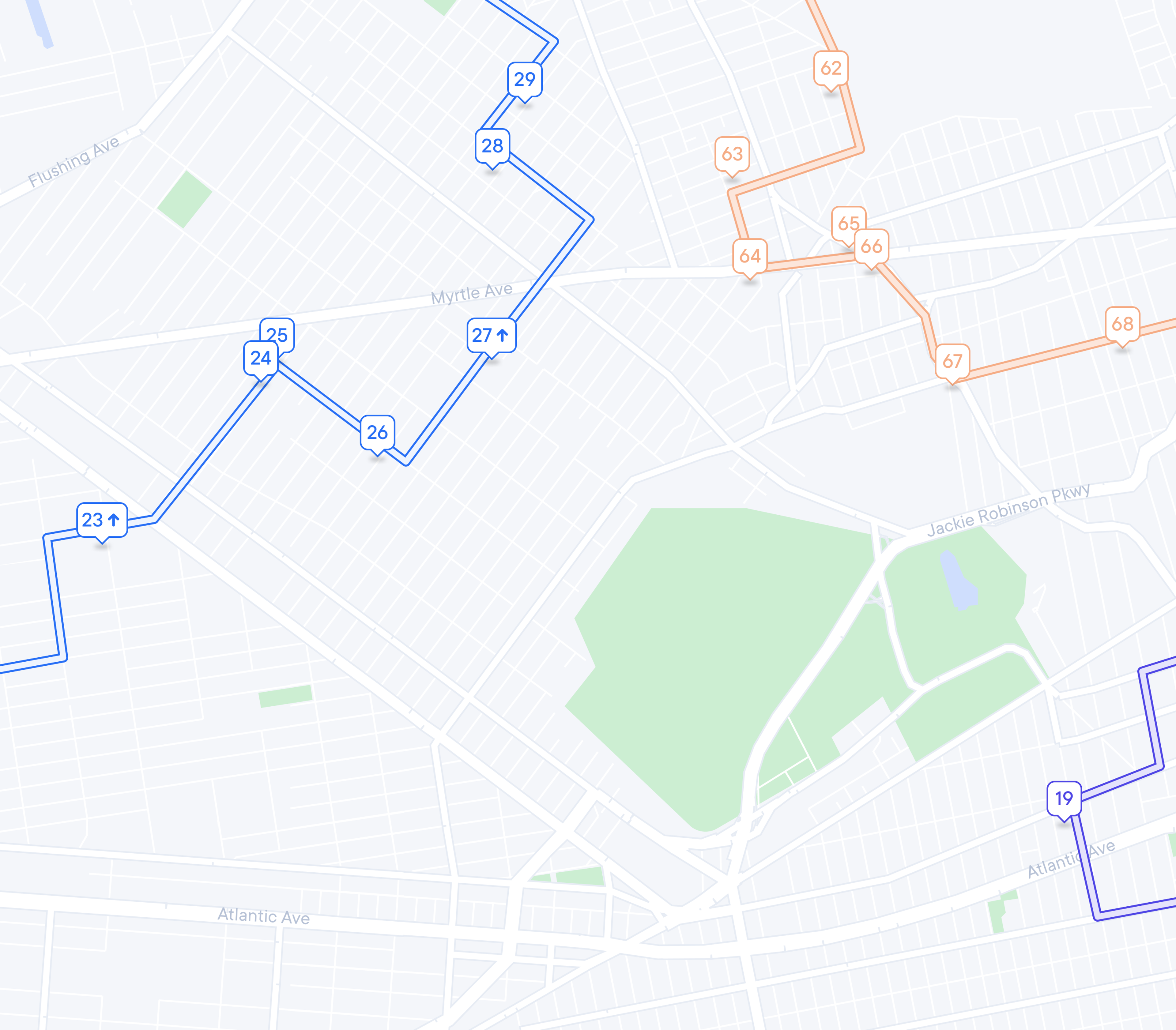 A map showing three numbered routes in blue, orange, and purple, with street names and parks.