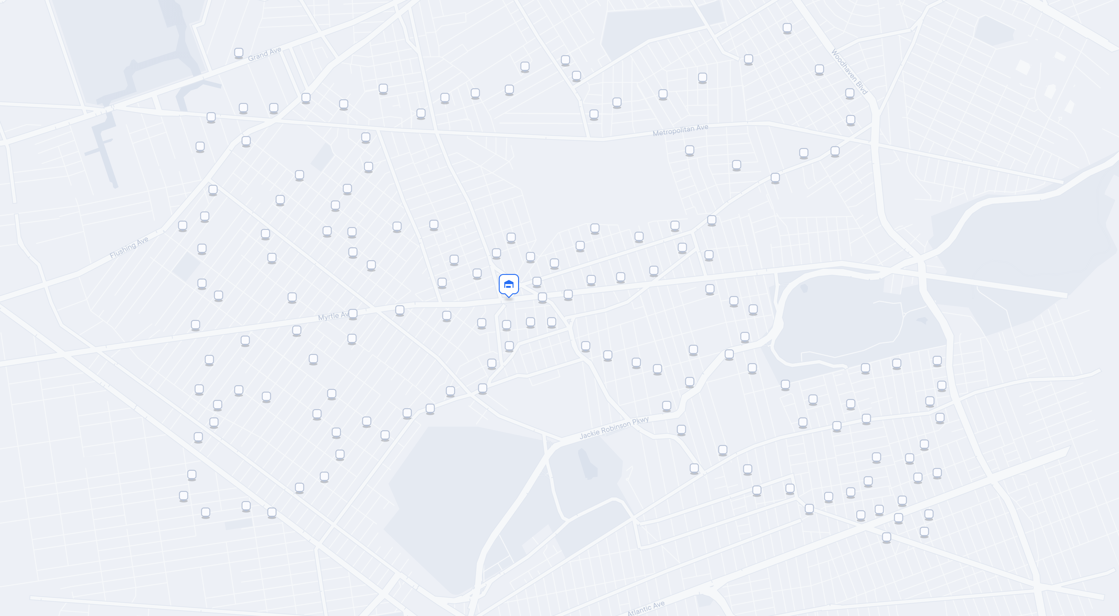 A light grey city street map overlaid with numerous small, square grey icons representing delivery or pickup locations. A central icon shaped like a vehicle indicates a depot or starting point. No visible route lines are shown, indicating that no routes have been assigned yet.