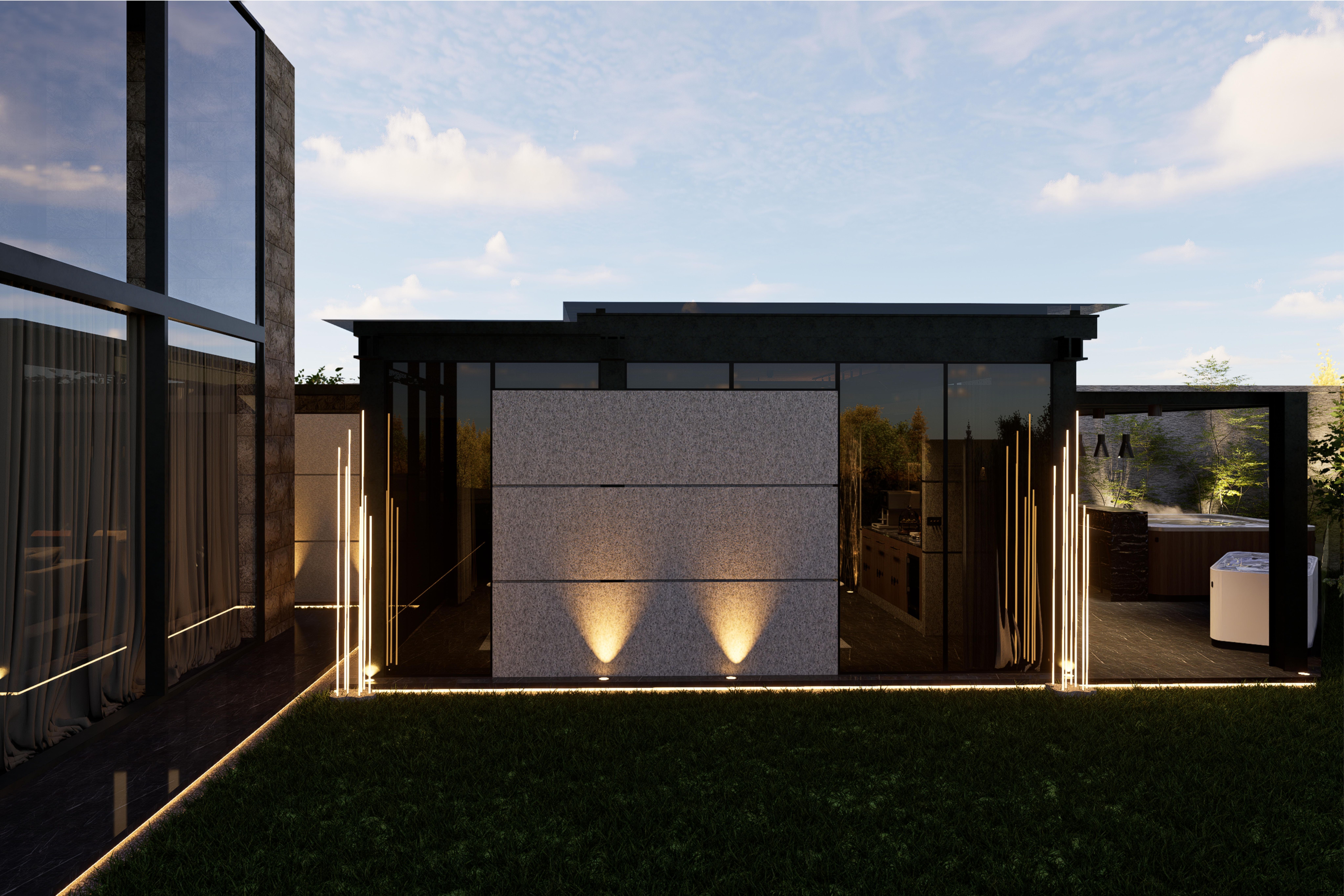 Pezo Spa - Dark-framed glass pavilion at dusk, with two ground uplights washing a stone-clad wall above the lawn.