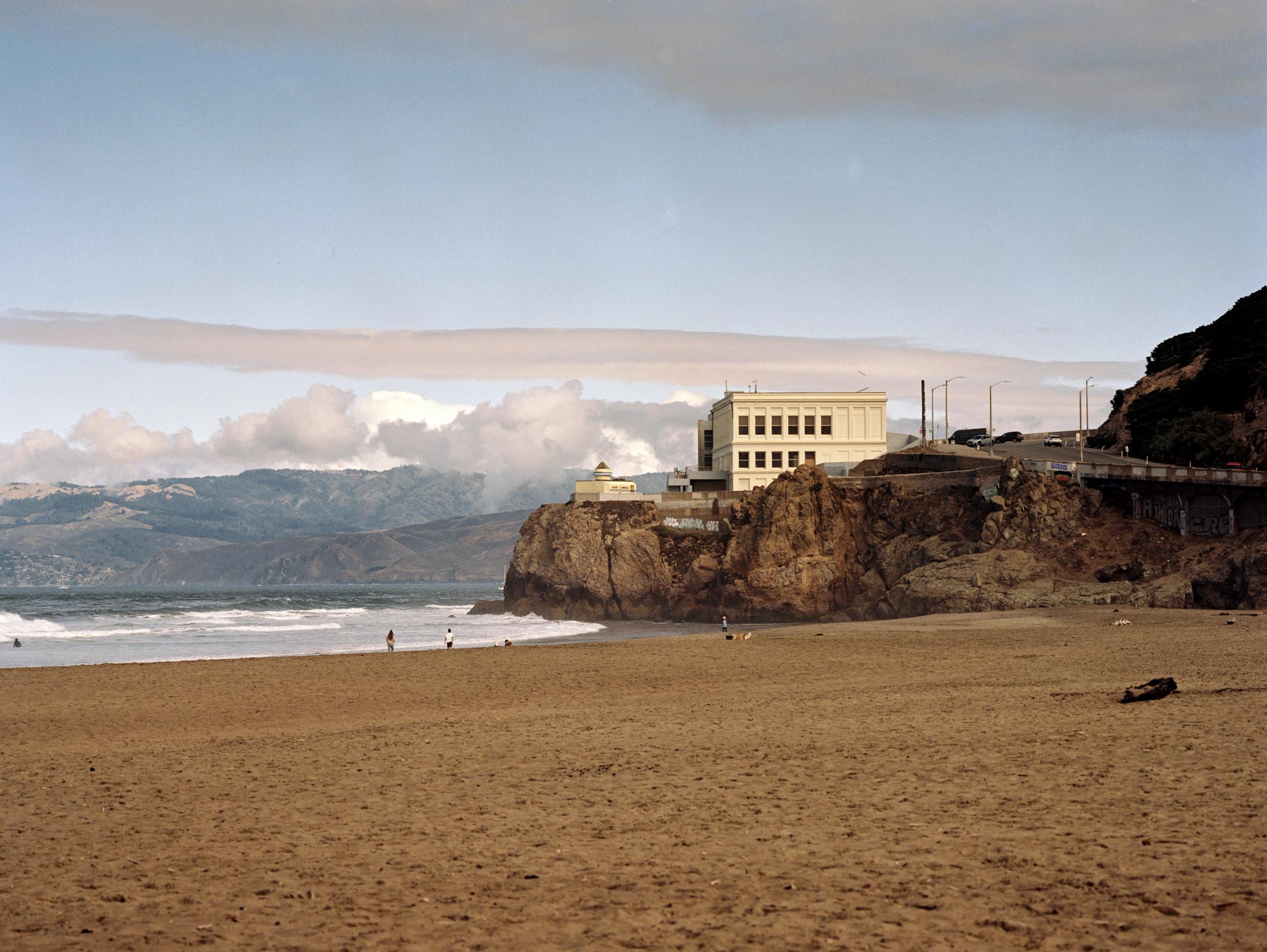 Ocean Beach in San Francisco, the Cliff House perched on the bluff above the sand, shot on Mamiya 7 film