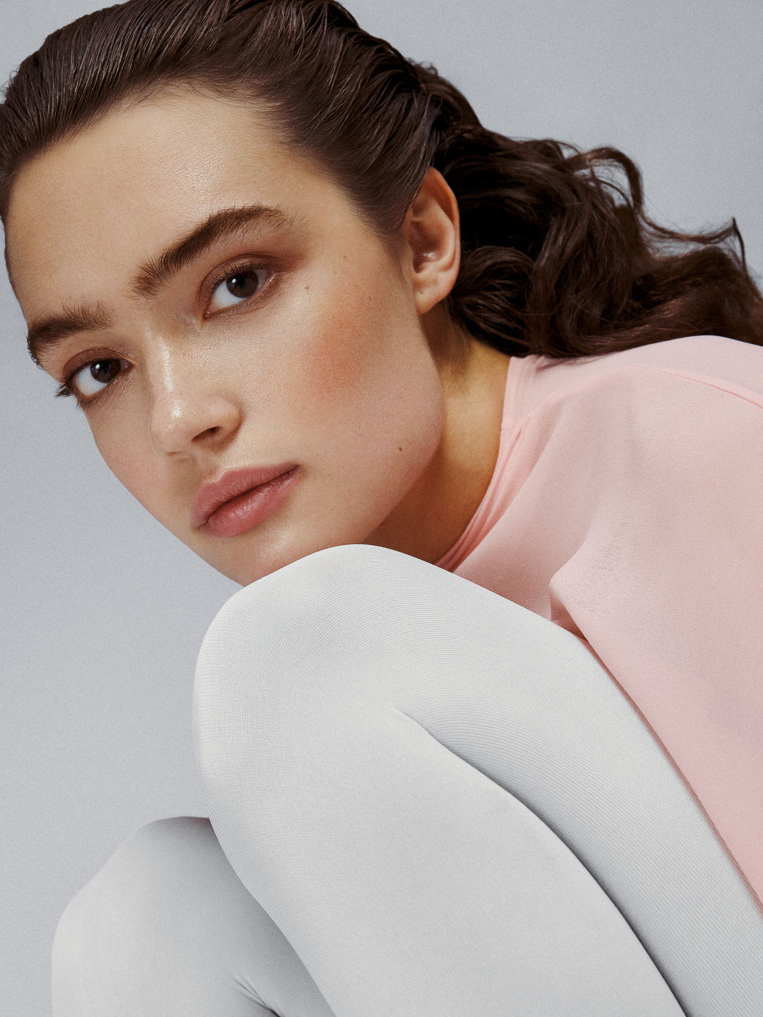 Kollektiv MGMT model Sasha Kichigina in a close-up portrait, pink top and white tights
