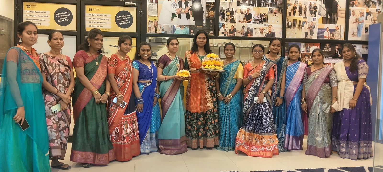 Women staff of Bharosa Hospitals in sarees and half-sarees holding Bathukamma