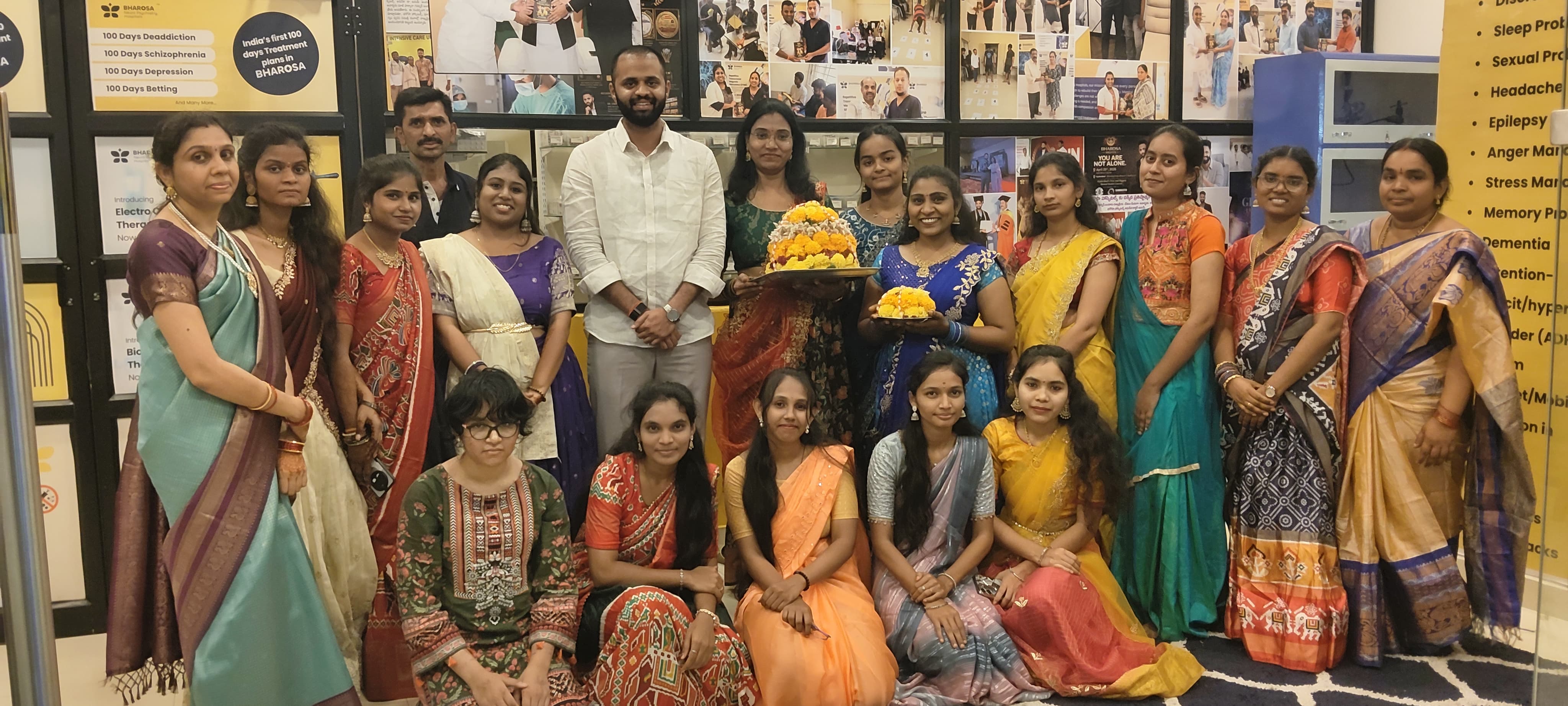 Dr. Uday Kiran with the Bharosa Hospitals team in traditional attire holding Bathukamma flower arrangements