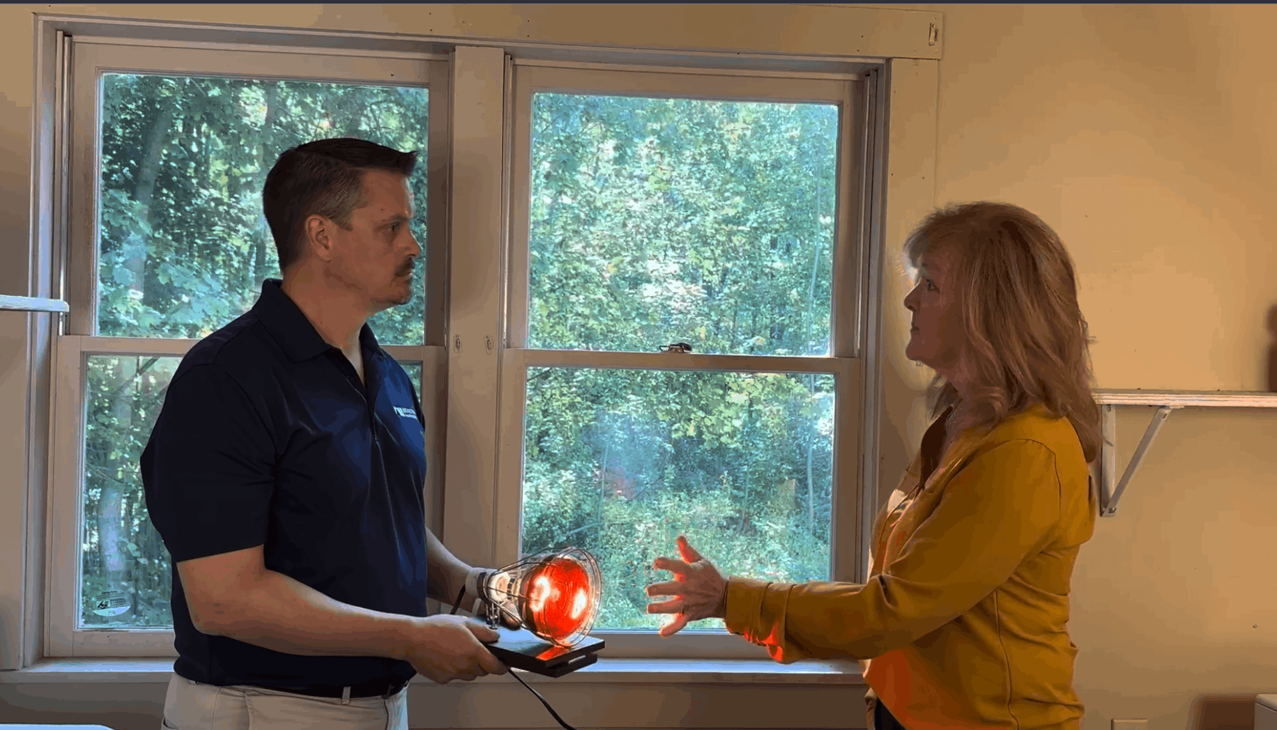 Homeowner points to window that needs replacing during consultation