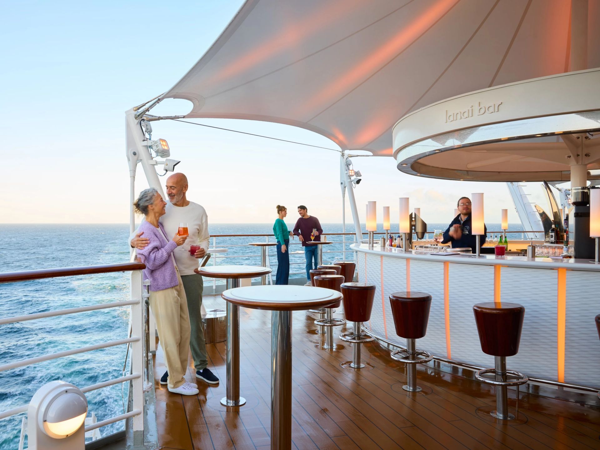 Lanai Bar at sunset with BLOOM bar stools and standing tables overlooking the sea on AIDAdiva