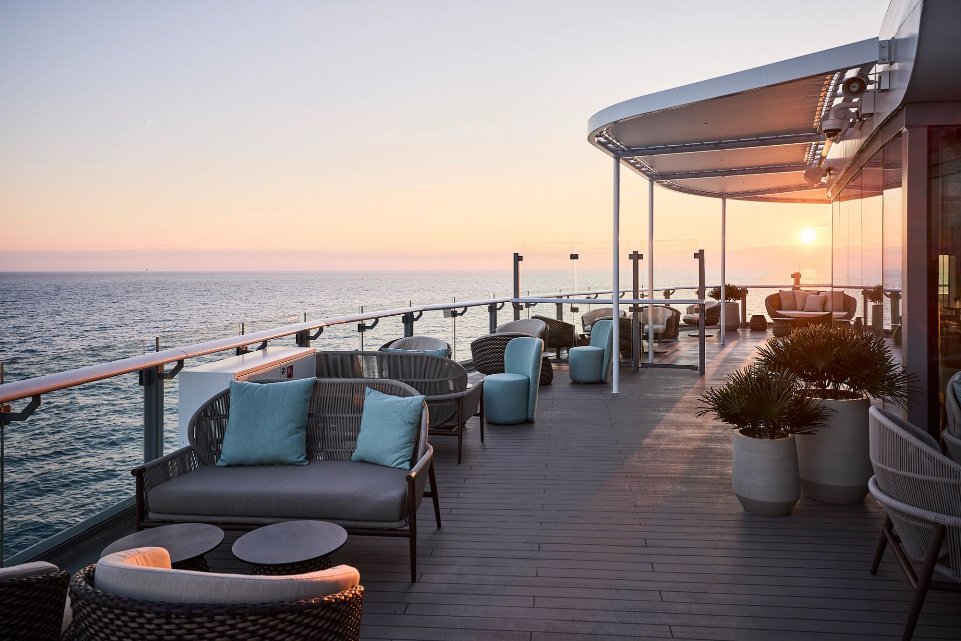 X-Coast outdoor lounge on Mein Schiff Relax at sunset — BLOOM woven daybeds and armchairs with ocean view