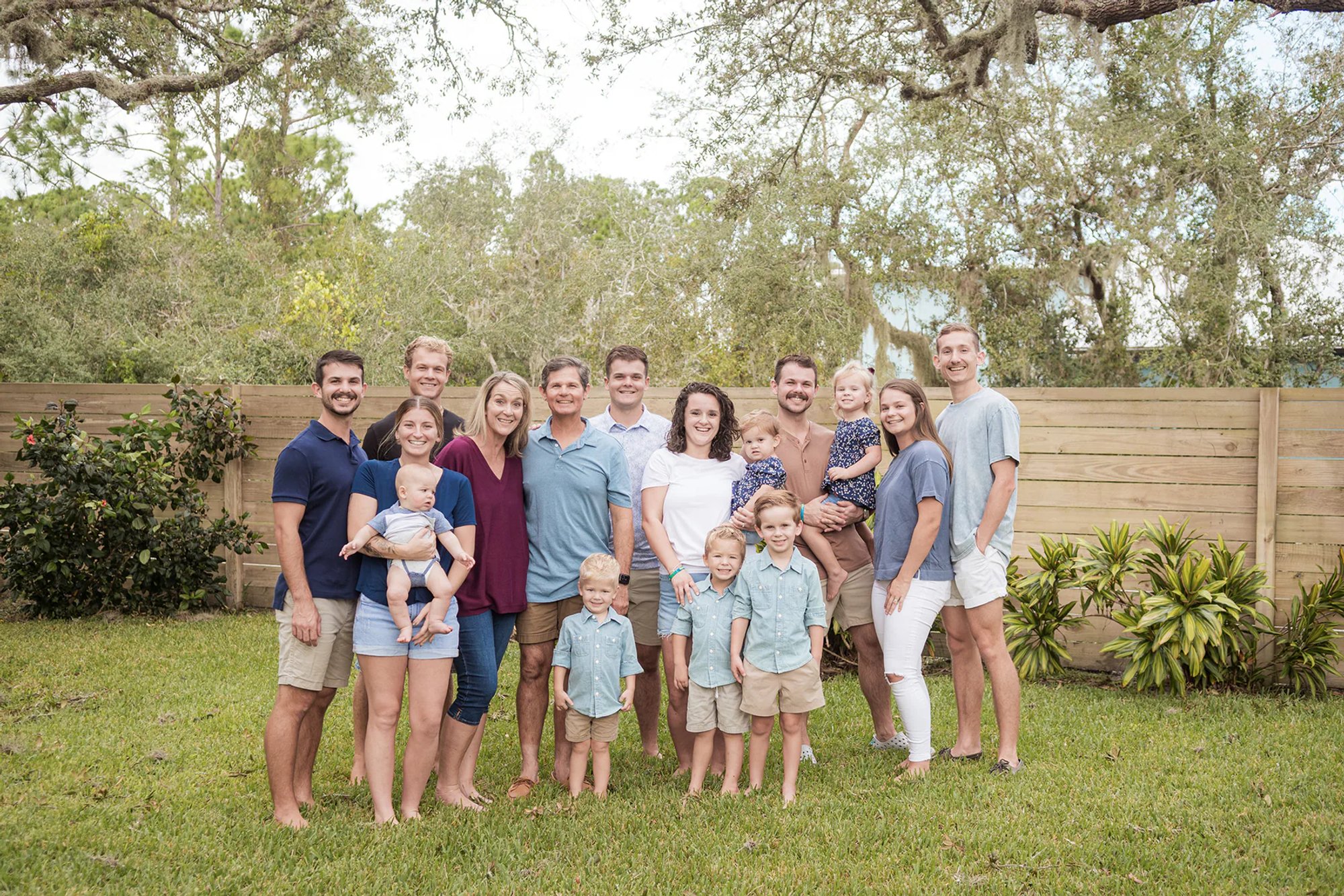 Smiling extended family gathered together on a lawn.