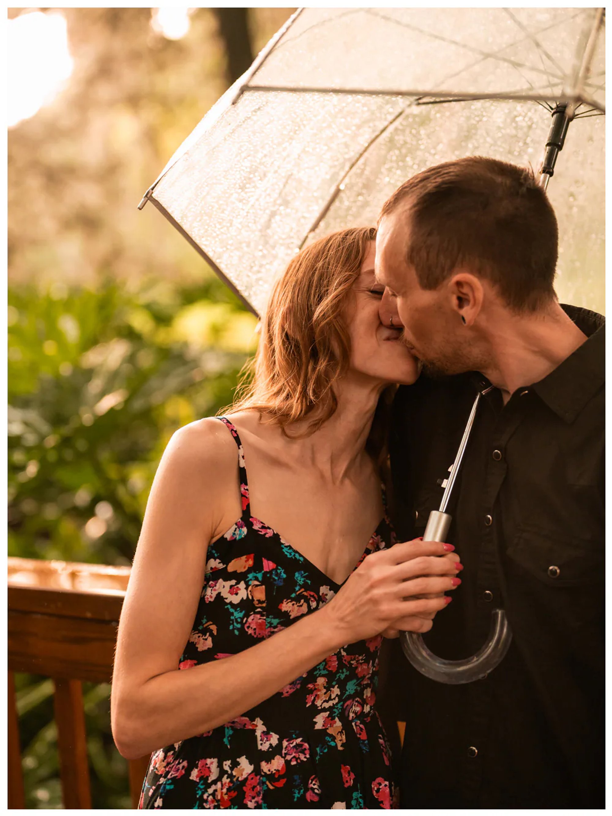 Close-up of a couple kissing beneath a rain-covered umbrella at Washington Oaks Gardens State Park.