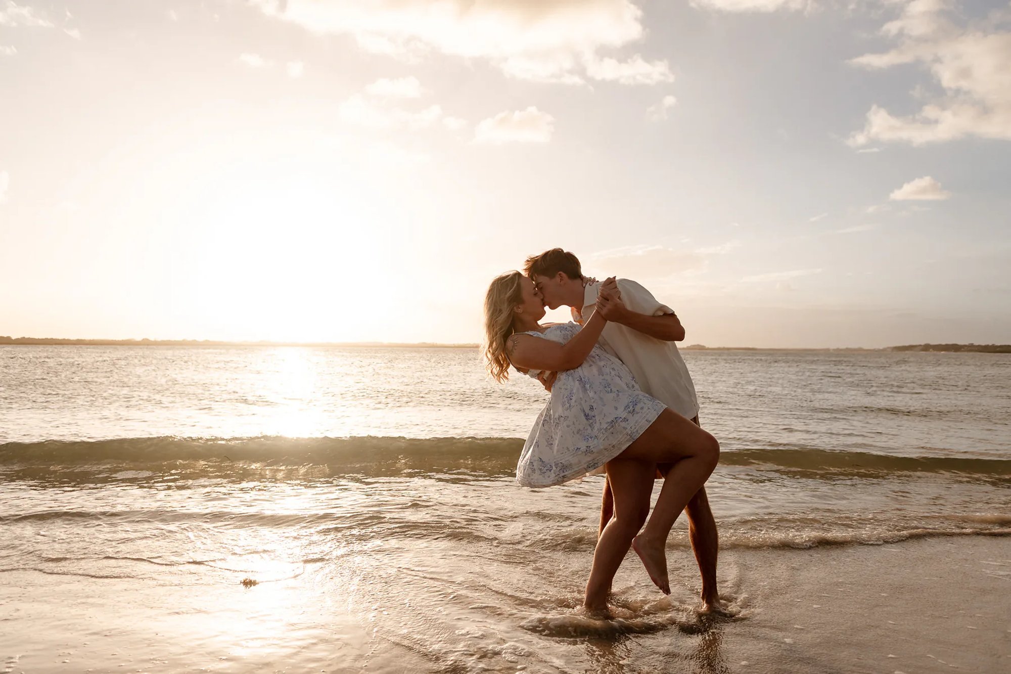Beautiful engagement photograph new smyrna beach sunset couple kissing and dip
