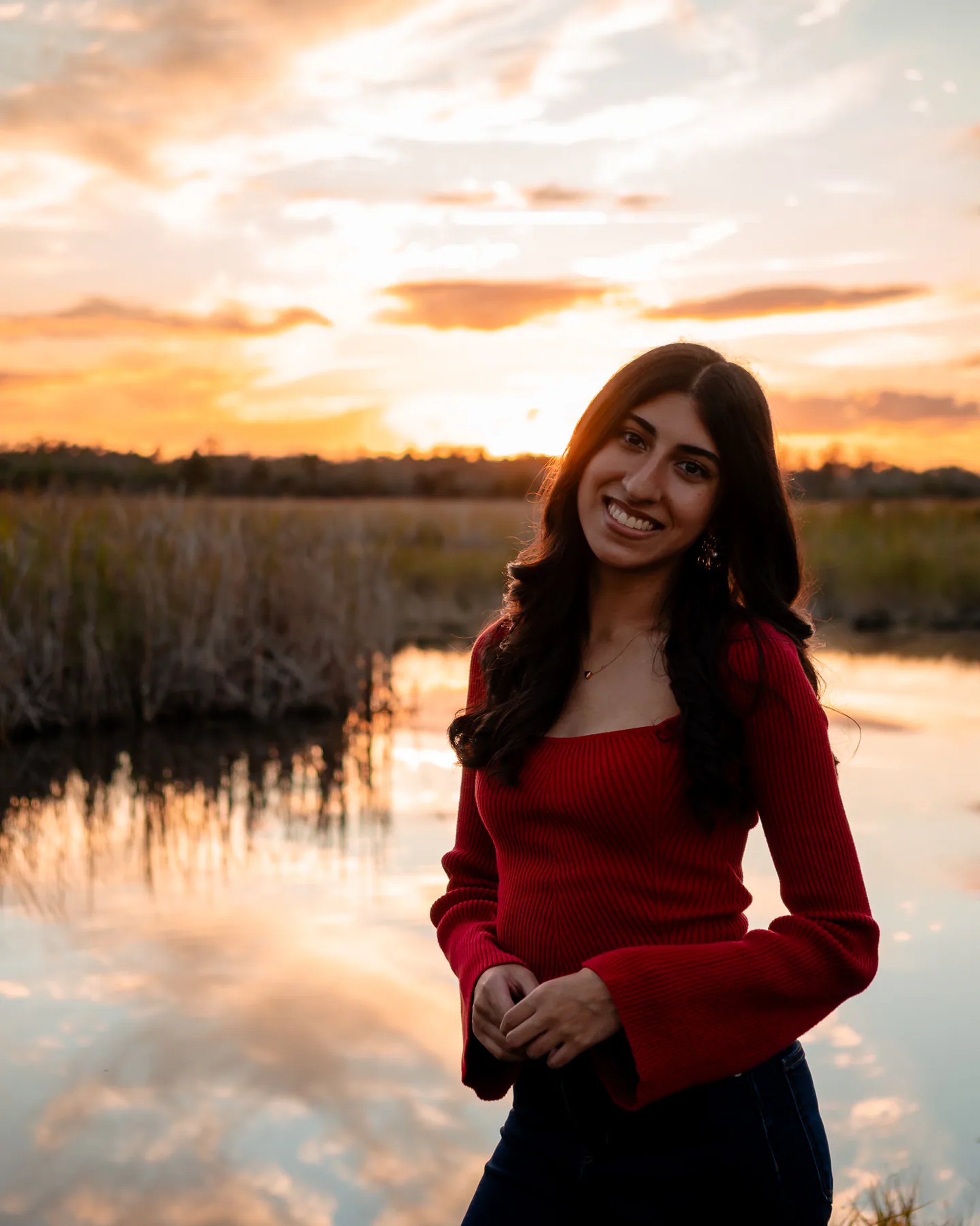 Ahaana by the water at sunset for Lake Woodruff senior portraits
